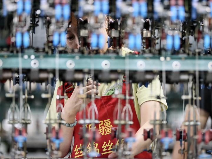 2025年7月29日，工人在新疆丝锦丝绸纺织有限公司生产车间内的自动缫丝机上作业。近年来，新疆塔城地区乌苏市引进桑蚕茧丝绸智能化全产业链项目，鼓励农民种桑养蚕，拓宽兴边富民新“丝”路。