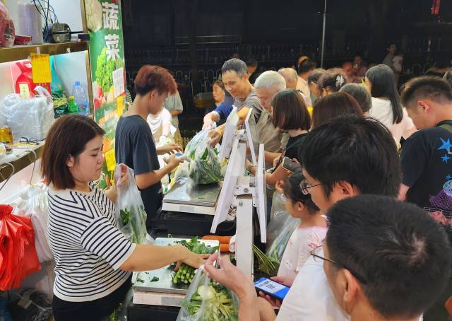 23日晚7点,广州市天河区东方三路,一家社区农贸商店,市民们正在选购新到货的大批蔬菜。 23日晚7点,广州市天河区东方三路,一家社区农贸商店,市民们正在选购新到货的大批蔬菜。