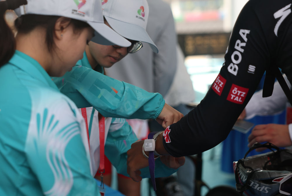 11月8日,志愿者为参赛选手佩戴通关手环。新华社记者 张晨霖 摄