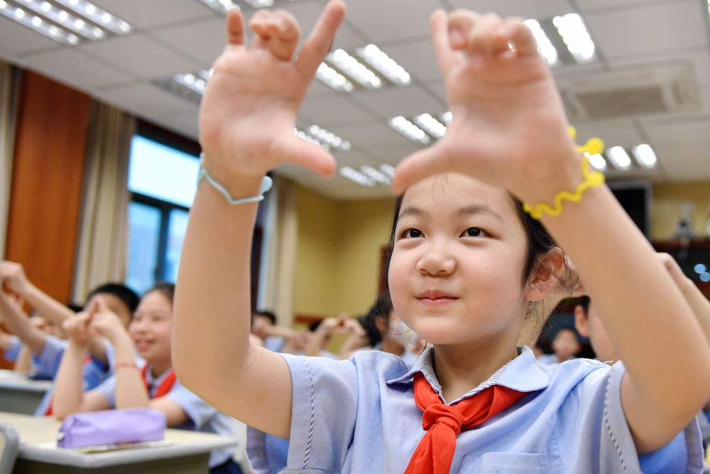 2023年6月5日，在浙江省湖州市长兴县第一小学，学生在县疾控中心党员志愿者的指导下利用互动小游戏进行优势眼检查。新华社发（谭云俸 摄）