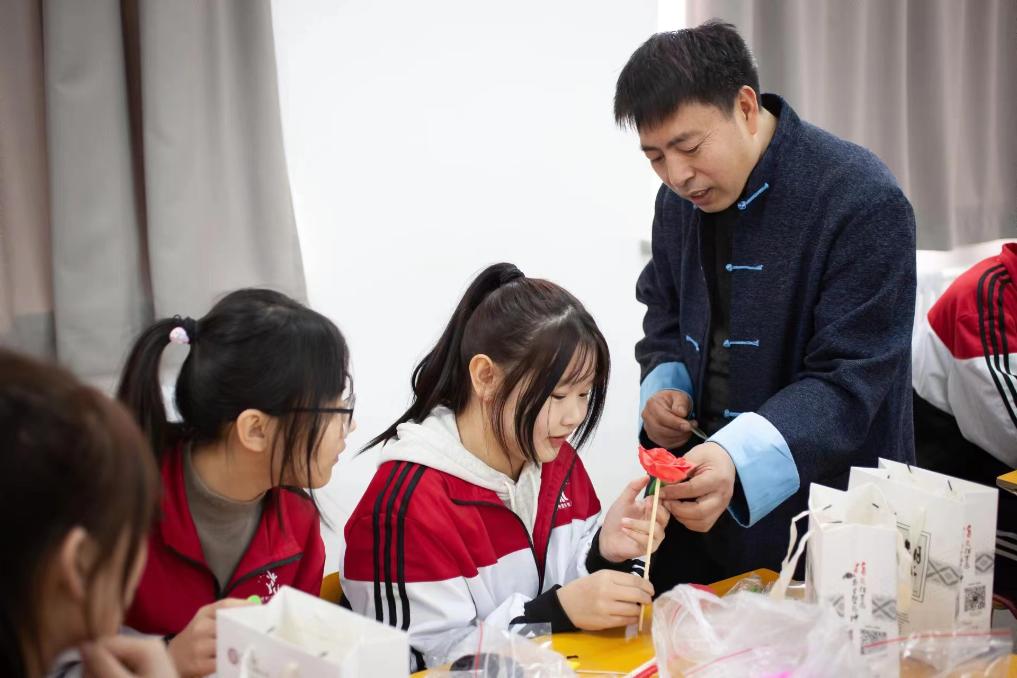 专家为辽宁省锦州市南丰技工学校就业见习生传授面塑技艺。受访者供图