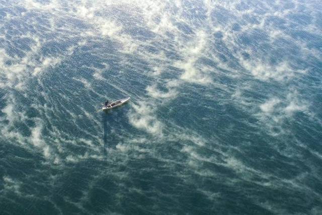 2022年12月18日,安阳乡白象湾水面上出现十几米高的水雾,一叶小舟在湖中静静行驶。(视觉中国) 2022年12月18日,安阳乡白象湾水面上出现十几米高的水雾,一叶小舟在湖中静静行驶。(视觉中国)