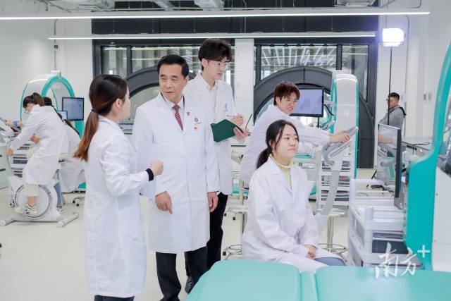 在中山大学深圳校区，中大医学院院长、中大附属第七医院院长何裕隆（左三）在实验室指导师生。