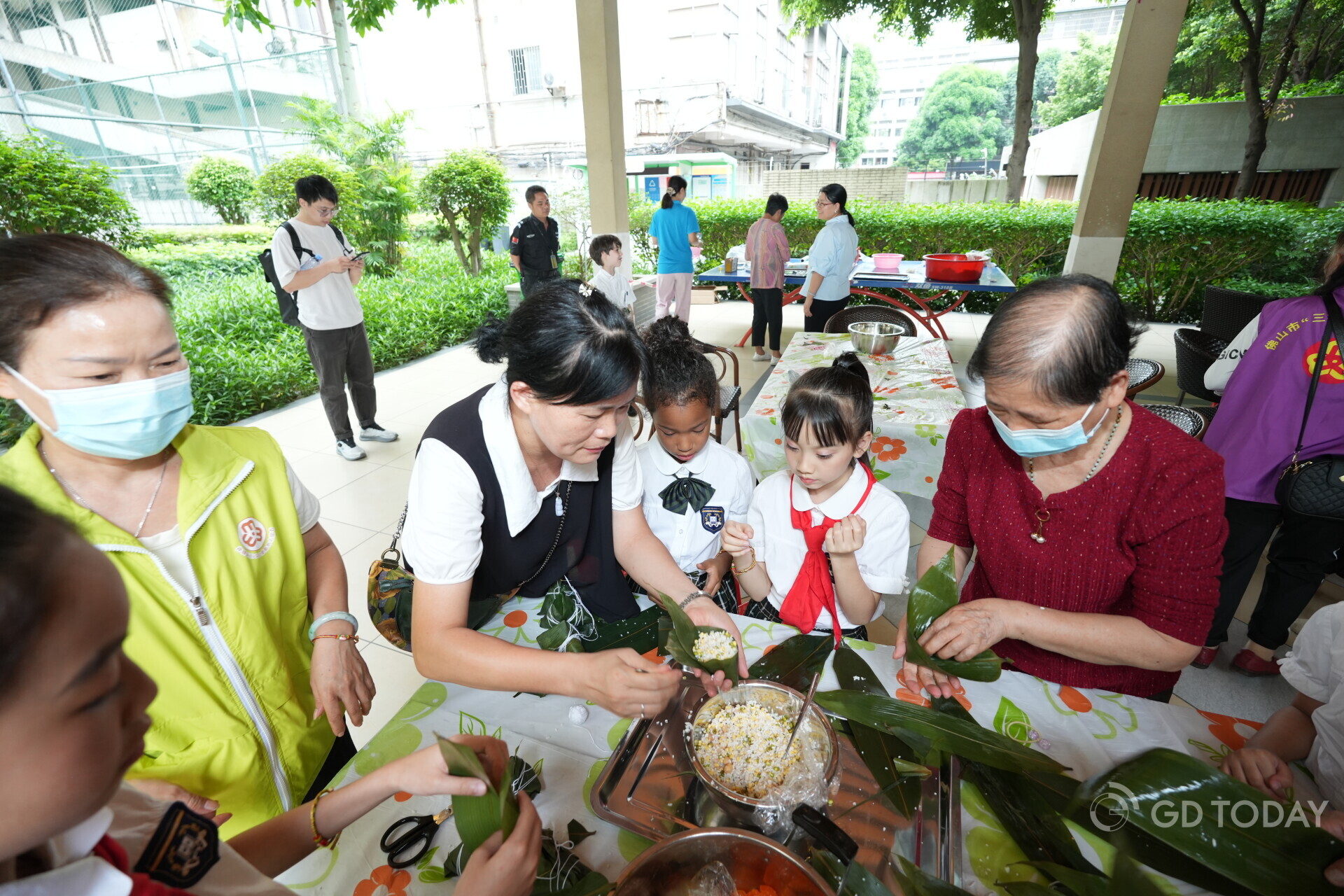 Adults and children gathered together to make zongzi. 南方+ 廖明璨 拍摄