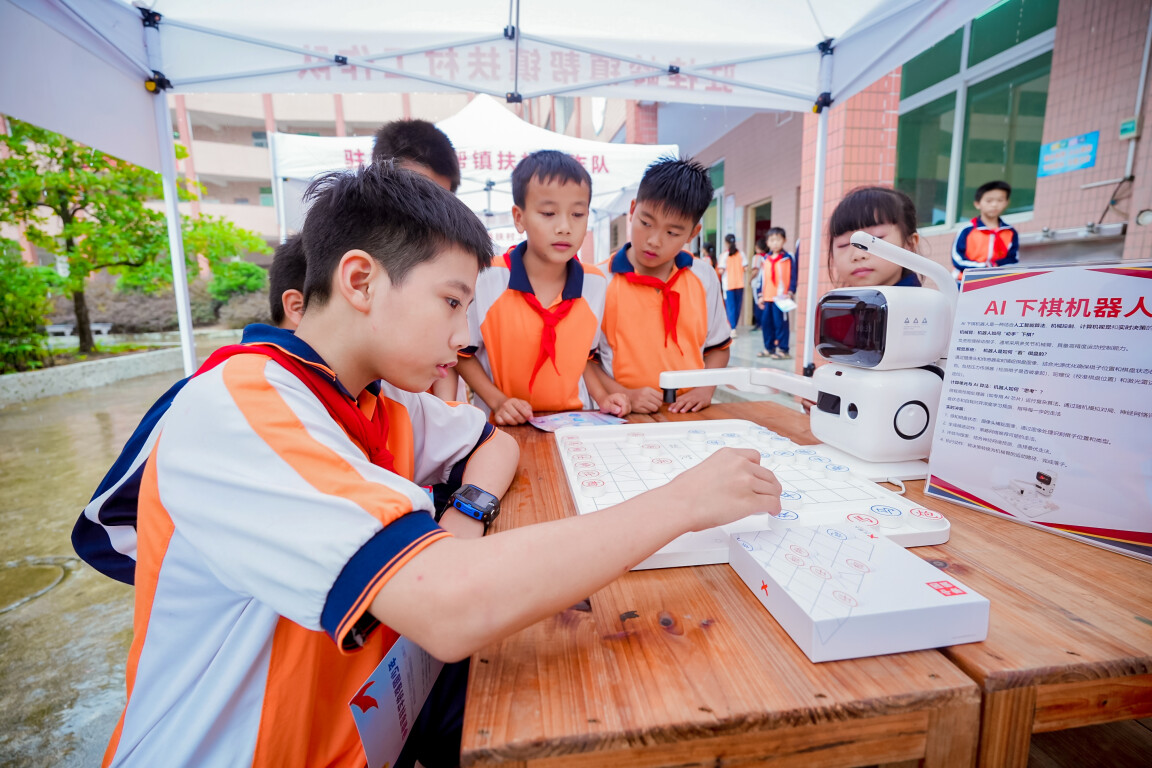 揭阳市揭东区桂岭镇玉白小学少先队员体验与AI机器人下棋。通讯员供图