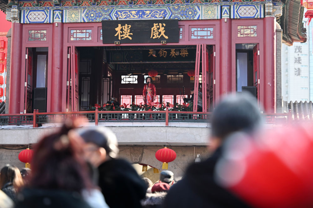 2024年2月10日，游客在天津古文化街观看演出。新华社记者 赵子硕 摄