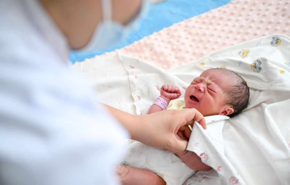 2月10日，在内蒙古乌兰察布市第三医院，医护人员在包裹一名刚出生的“龙宝宝”。新华社记者 连振 摄