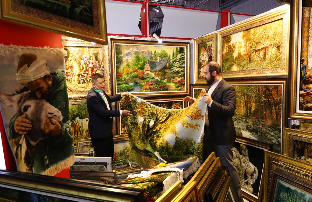 　　11月10日，在第六届进博会上，一名参观者在一家伊朗手工挂毯展位上查看一款风景画挂毯。（新华社记者方喆摄）