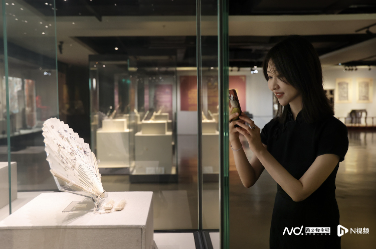广州十三行博物馆里陈列在展厅走道旁的象牙透雕双面广绣龙纹摺扇，吸引黎贝卡驻足拍照。