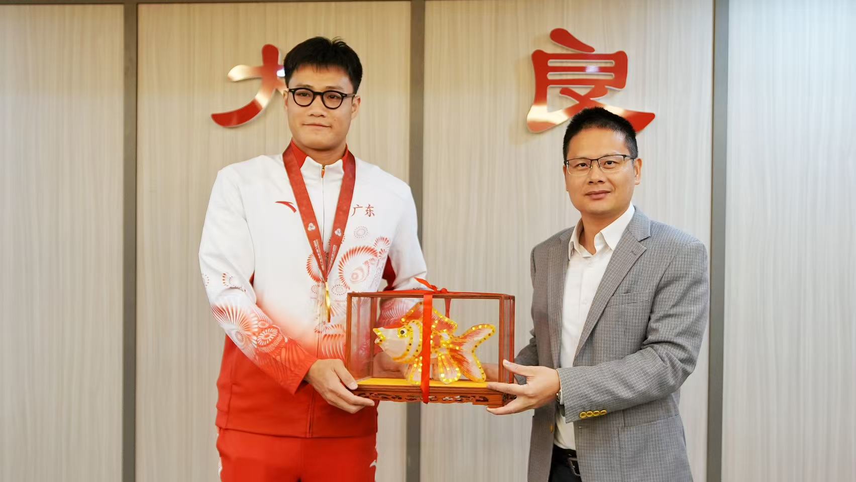 大良街道党工委书记钟德慰为陈钧豪送上纪念品。