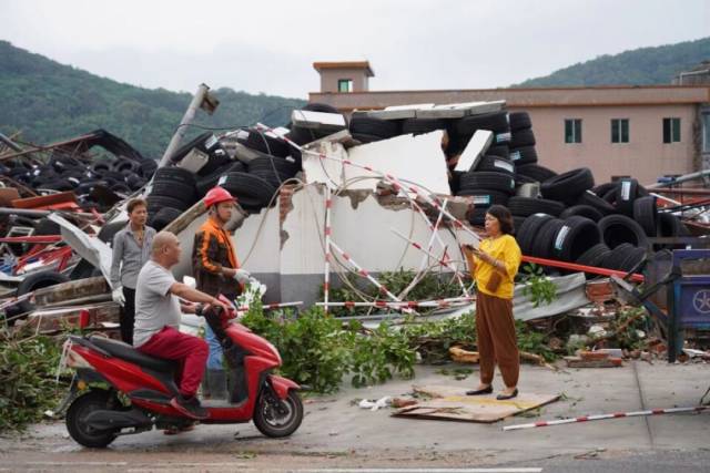 光明村的工人在收拾整理灾后现场，工厂老板清点计算损失。