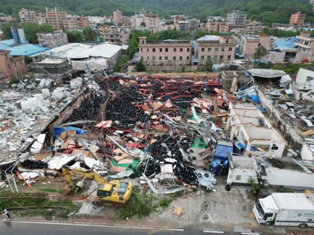 航拍光明村受灾现场，一间轮胎厂的货车被吹倒，建筑和生产材料一片狼藉。