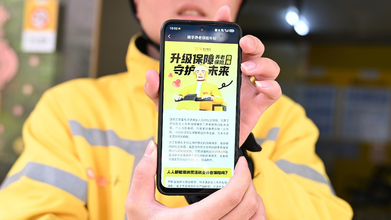 一位泉州美团外卖骑手展示收到的养老保险补贴试点通知（摄影/叶强）