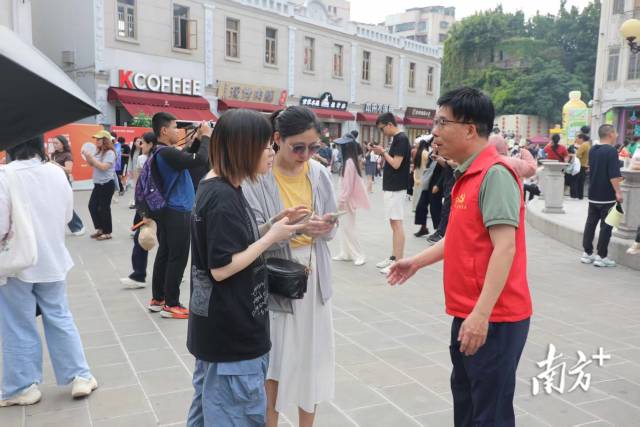 志愿者为市民游客提供便民服务。张晓宜 摄