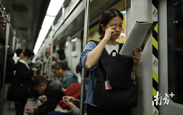 1月29日，广州地铁2号线车厢内，一名女孩倚靠车厢专注阅读书籍。