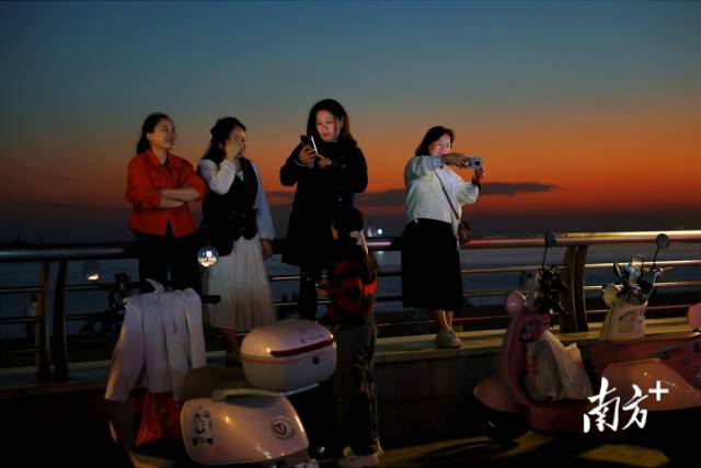 游客们在汕头南澳岛海边“打卡”美丽夕阳。