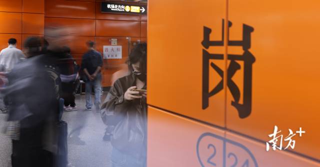 1月29日，嘉禾望岗地铁站的人流中，一名女孩专注翻看手机，沉浸其中。