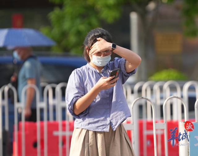 8月7日“立秋”前一天广州继续“火辣辣”，市民在户外用手遮挡阳光 梁怿韬 摄