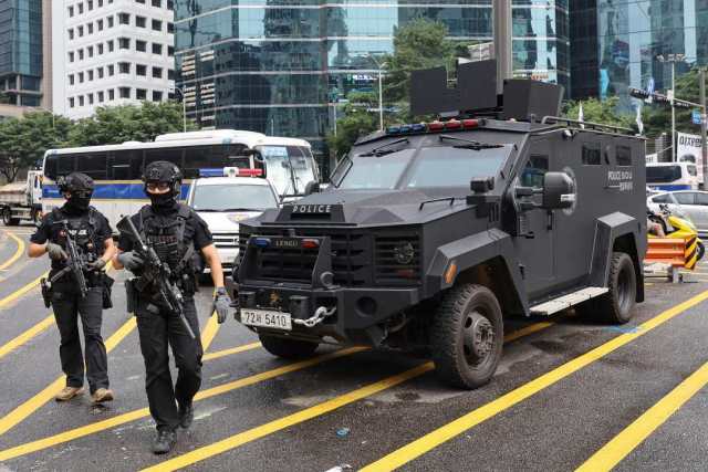 当地时间8月6日，韩国首尔，江南站附近部署了警察特警队员和战术装甲车。