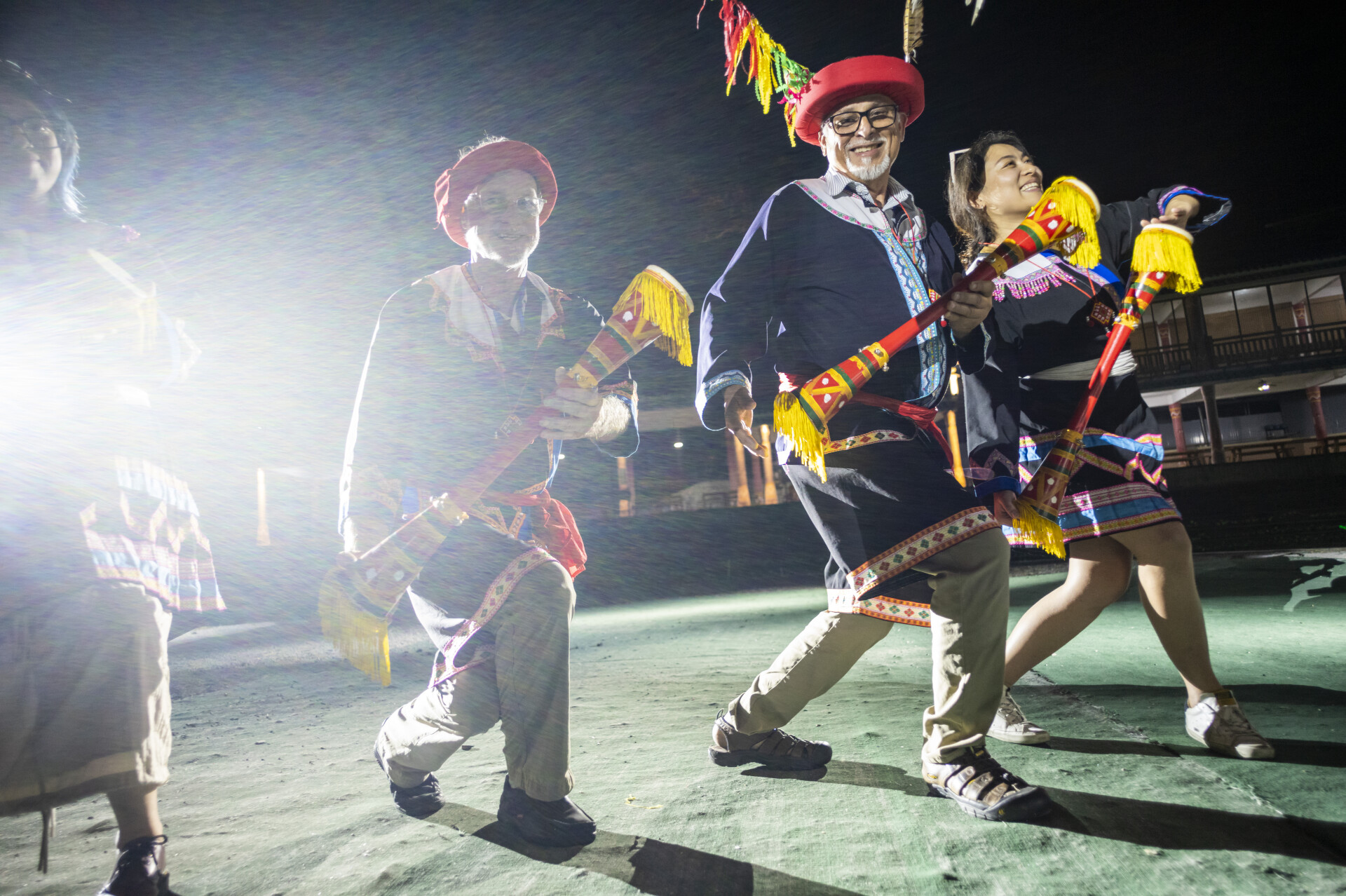 Photographers Irfan Khan and Michael Nelson wearing Yao ethnic minority costumes, dance during a bonfire party at Youling Yao Village, Liannan Yao Autonomous County in Qingyuan, Guangdong