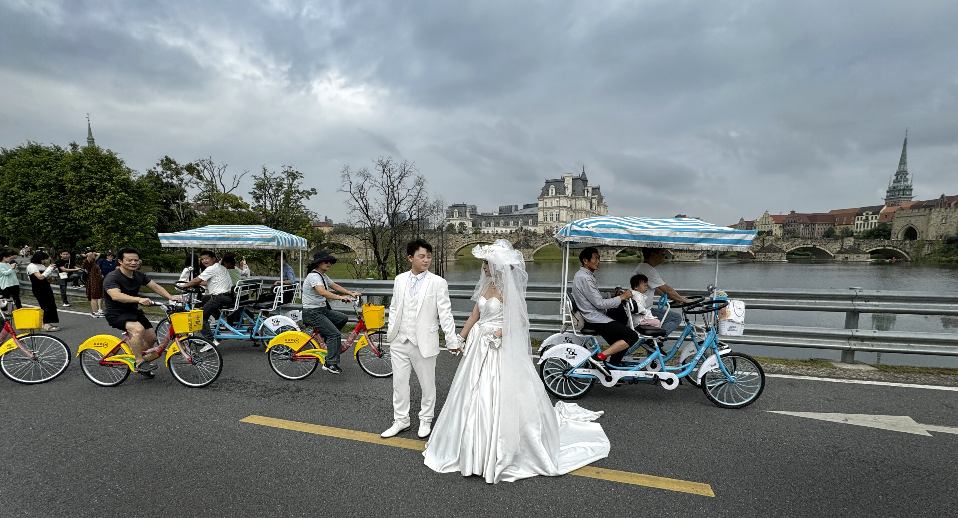 Happy newlyweds pose for pictures on a bridge, Songshan Lake Ecological Scenic Area in Dongguan, Guangdong
