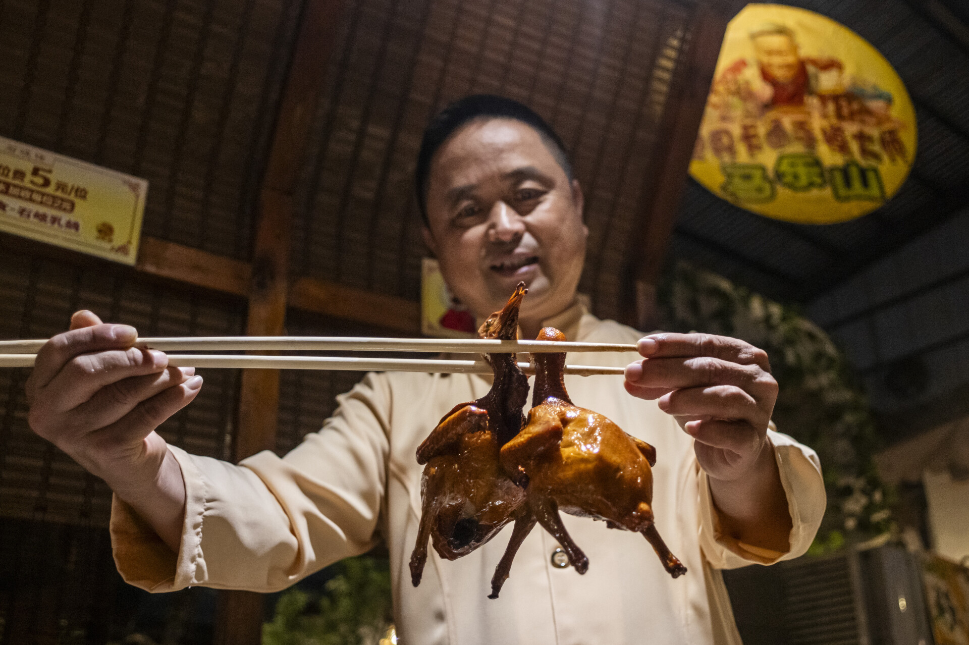 Chef cooks fried pigeons at Shiqilao Restaurant in Zhongshan, Guangdong
