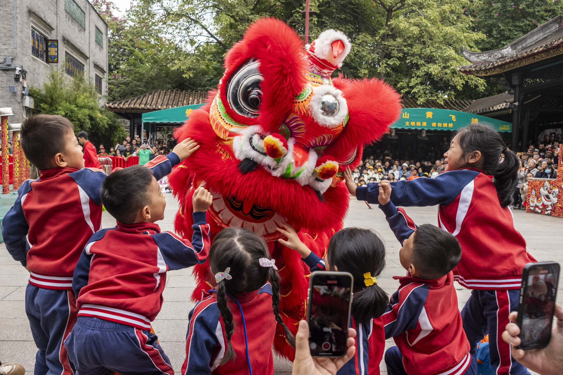 School kids touch the lion head for good luck in Foshan Ancestral Temple, Foshan, Guangdong