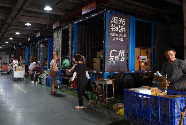 7月22日,在华强北一个电子市场旁,物流车集中在一起等待上货。