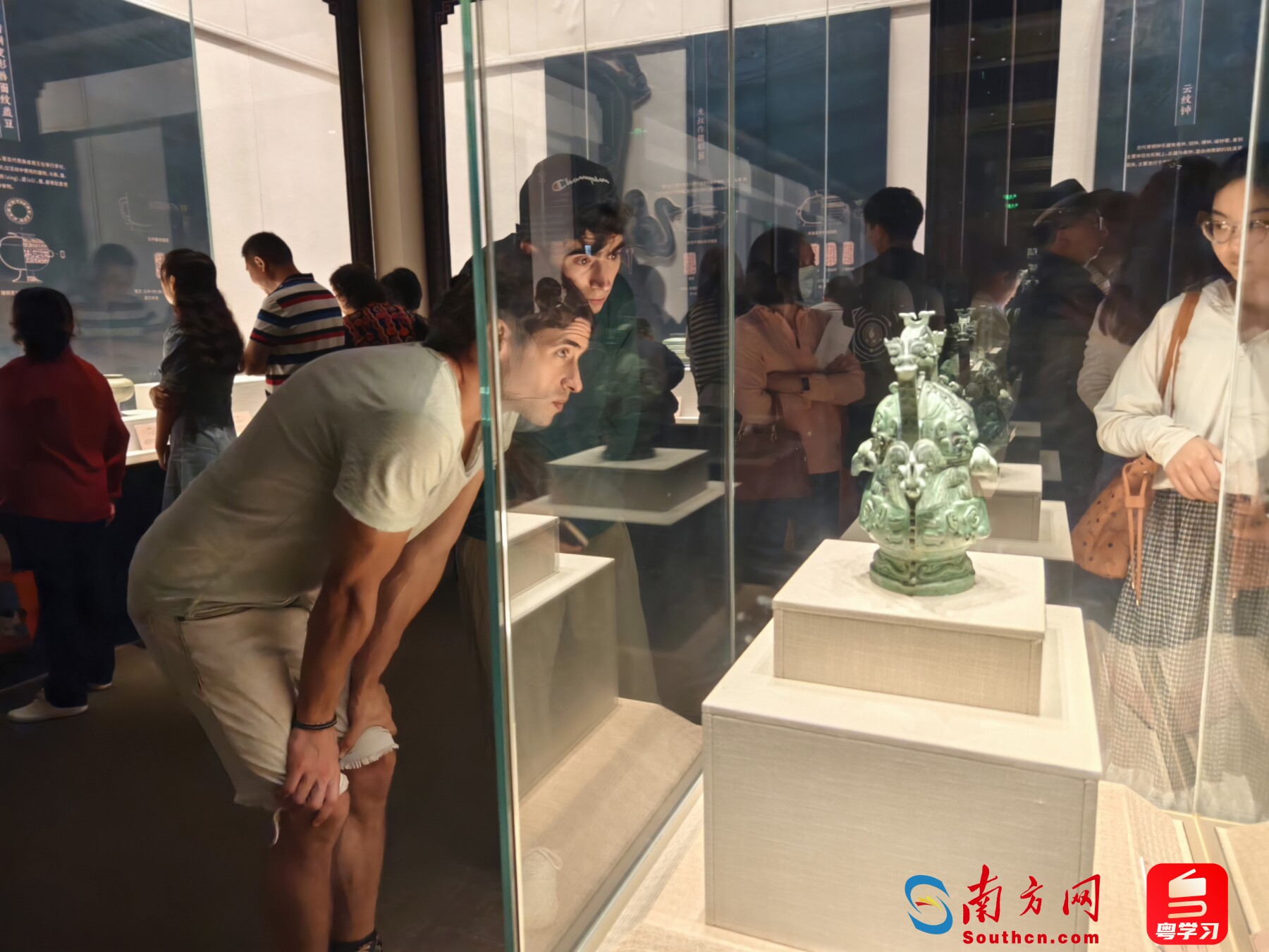 展览现场，外国人在观看青铜器。