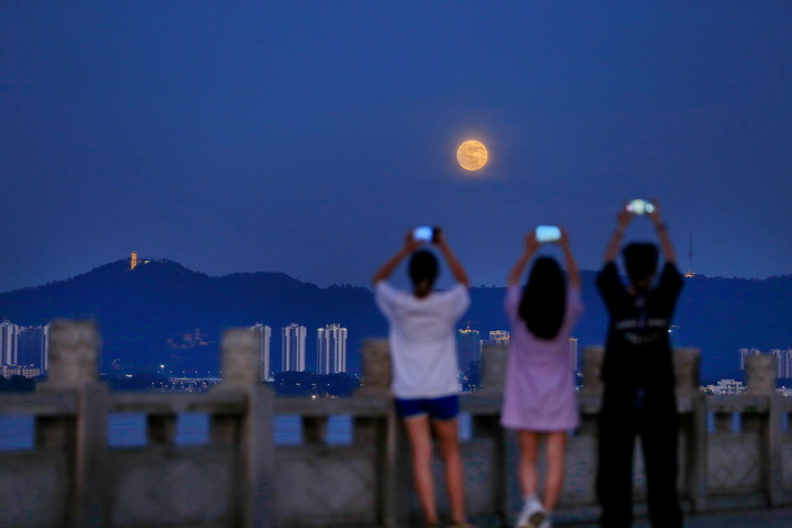 2022年7月13日晚，广东鹤山市民在西江河畔观赏“超级月亮”。 新华社发（黄继明 摄）