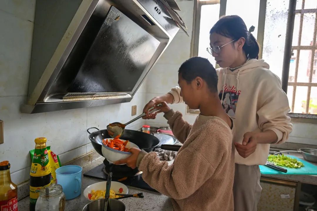 陈艳辉在教小美做饭，培养她的生活自理能力