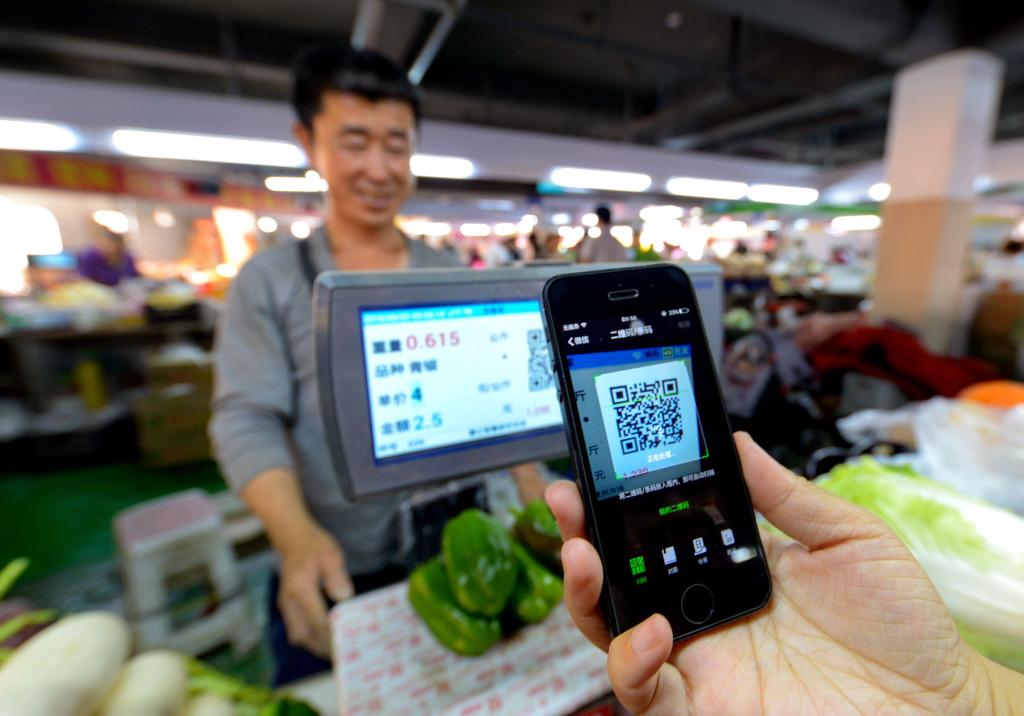 在河北省邯郸市一家便民市场，国移更便<strong>j9</strong>消费者在扫码支付购买蔬菜。动支第扫新华社记者王晓 摄