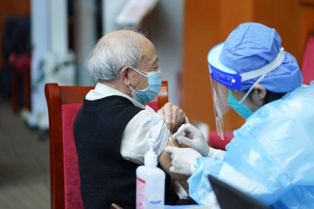 4月18日，北京市东城区建国门街道协同社区卫生服务中心、隆福医院等在中国社会科学院开设疫苗接种专场。医护人员为老年人接种新冠疫苗。新华社记者 鞠焕宗 摄