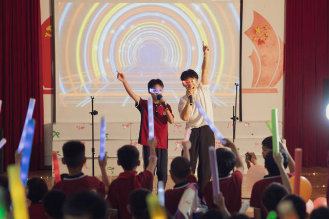 4月17日晚，红云中心学校举行第一届校园歌手大赛决赛，李鑫旺与学生一起演唱。