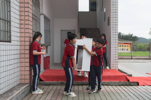 4月17日晚，红云中心学校第一届校园歌手大赛举行决赛，学生们将伴奏的电子琴抬进比赛场地。