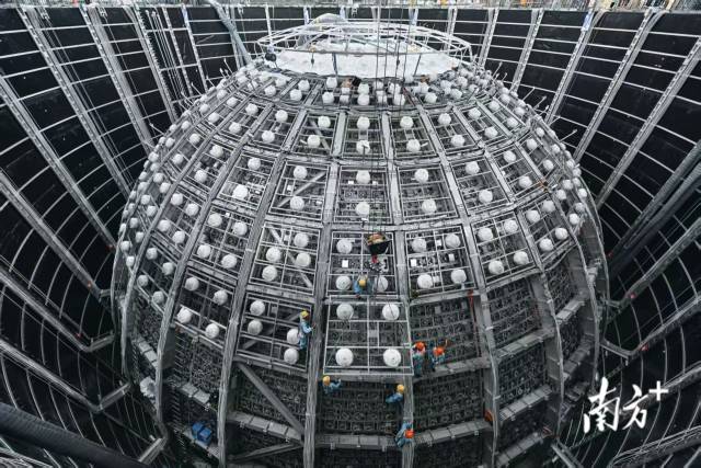 江门中微子实验探测器,中心探测器外工人正在高空安装光电倍增管模块,那是探测器的眼睛。 刘悦湘 摄 江门中微子实验探测器,中心探测器外工人正在高空安装光电倍增管模块,那是探测器的眼睛。 刘悦湘 摄