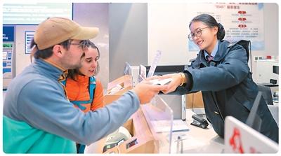 外籍旅客在云南香格里拉站“香巴拉·金花”服务台购票。杨紫轩摄(新华社发)