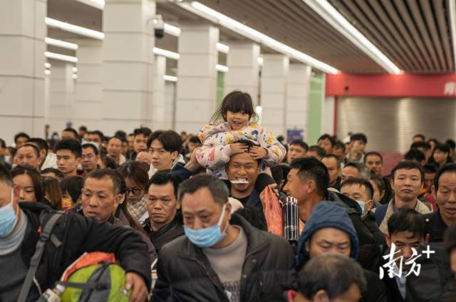 　　1月26日凌晨，从广州站前往四川渠县的春运首班列车即将启程，一位父亲将女儿举过头顶准备进站上车。
