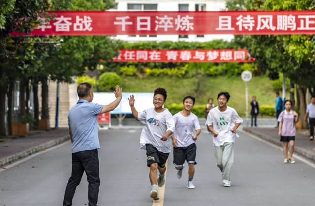 6月7日，在贵州省黔西一中考点，考生与老师击掌鼓劲后奔赴考点。 新华社发（范晖摄）