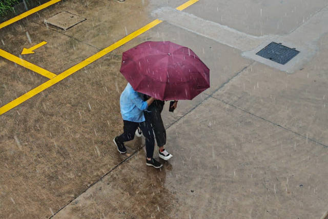 行人在雨中穿梭。