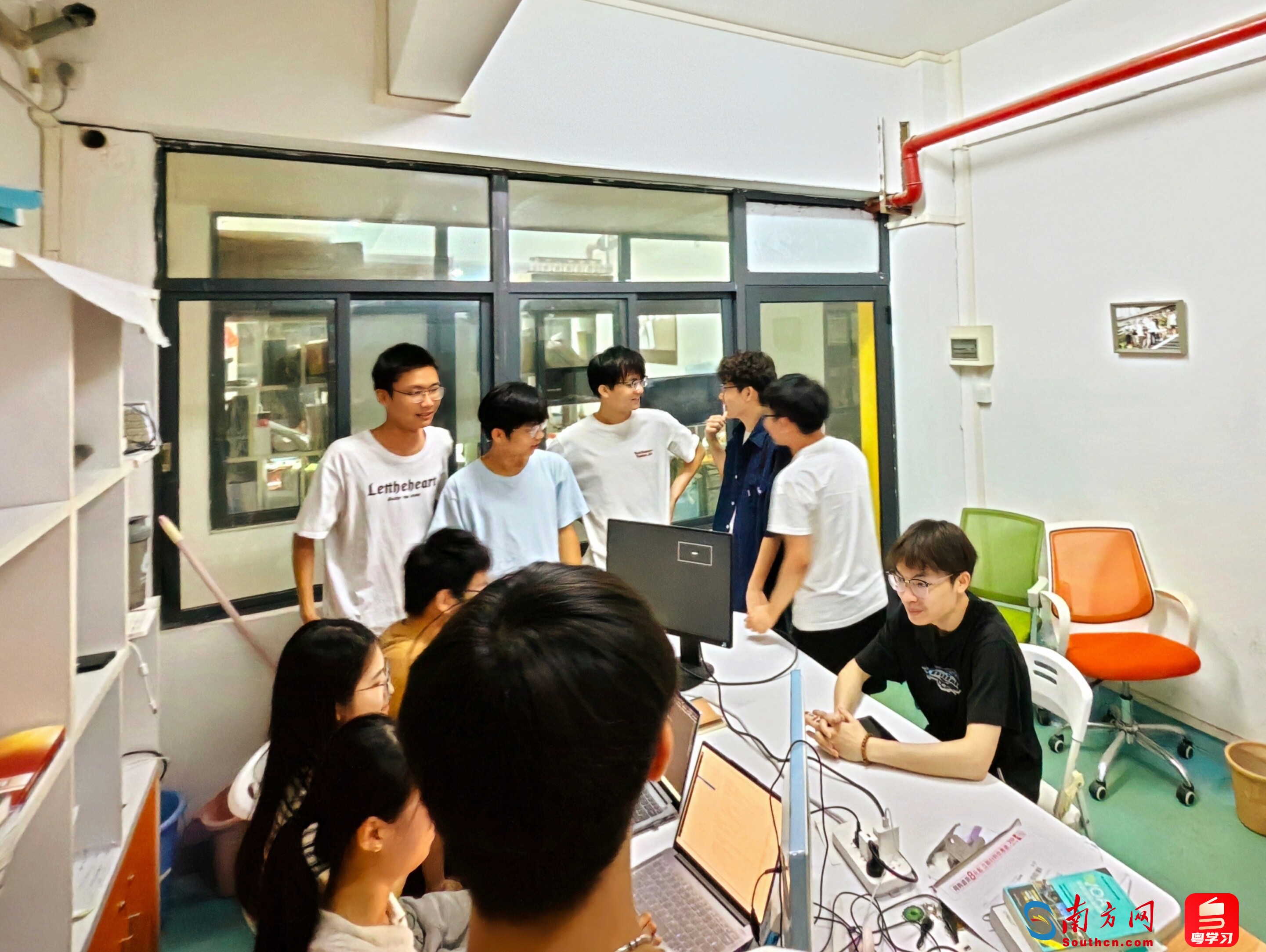 广工学子在实验室讨论技术难题。