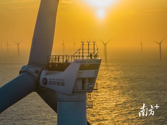 广东省汕尾，中广核海上风电项目工作人员正迎着夕阳检修风车，他们身后近百台巨大的风车不停转动，将海风能转化为绿色电力 
