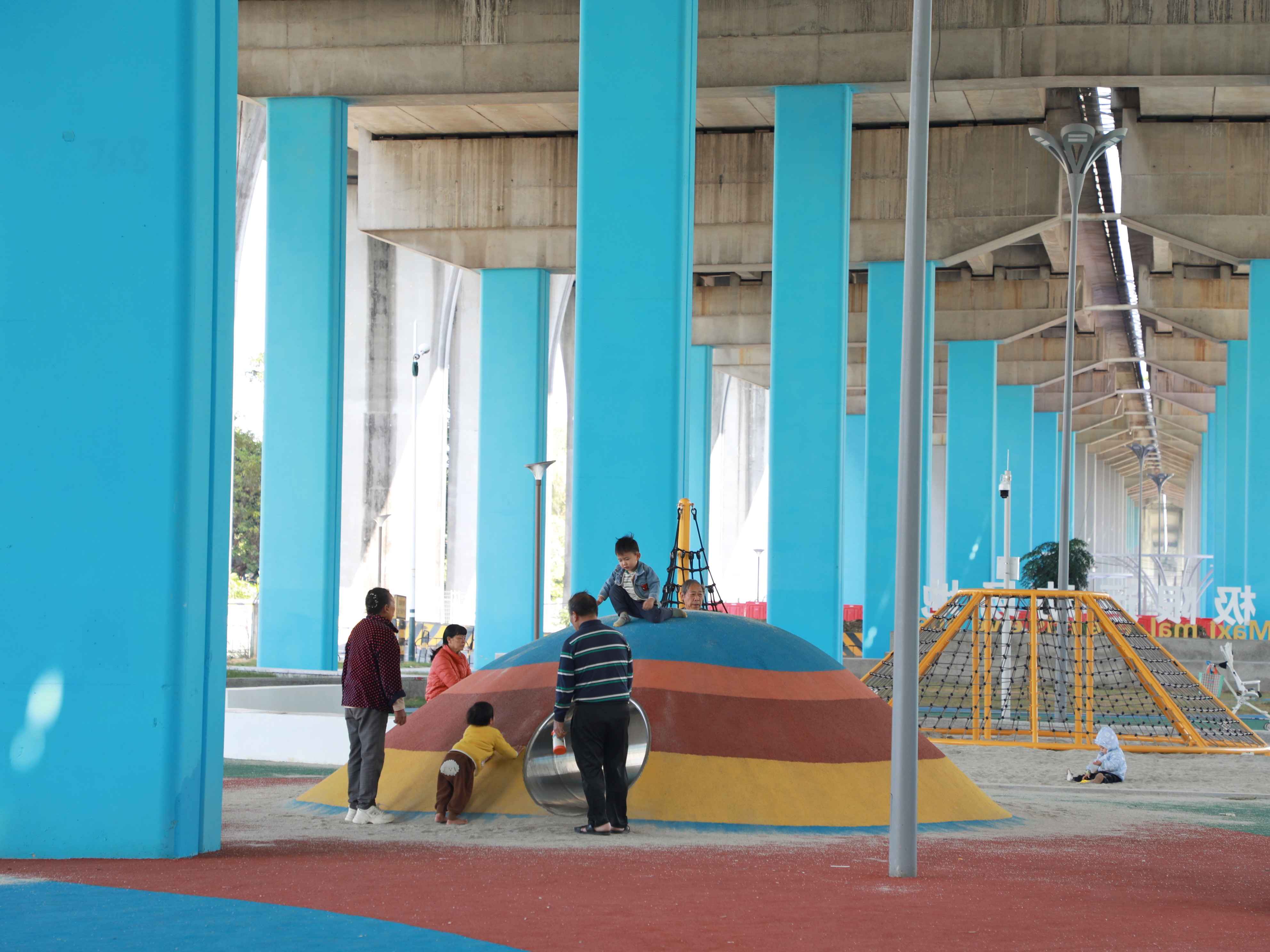 桥底变身色彩斑斓的游乐场，孩子们在家长陪伴下欢乐嬉戏（摄影：陈洁纯）