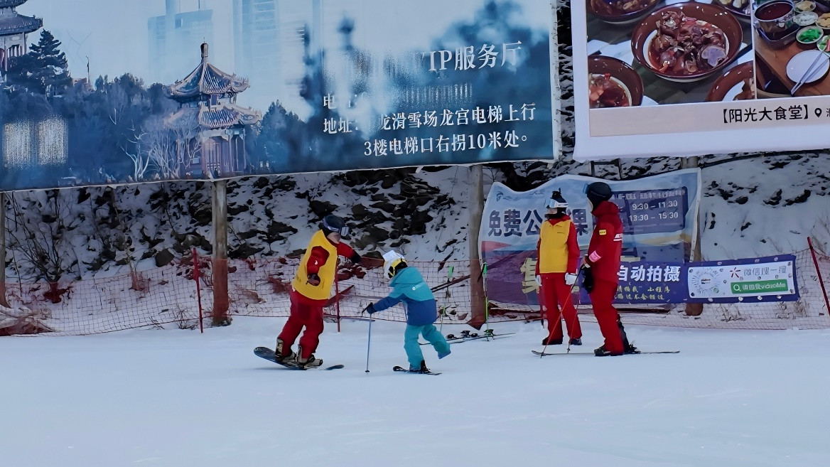 （万龙雪场，滑雪教练在教一位“新手小白”学习使用双板。）