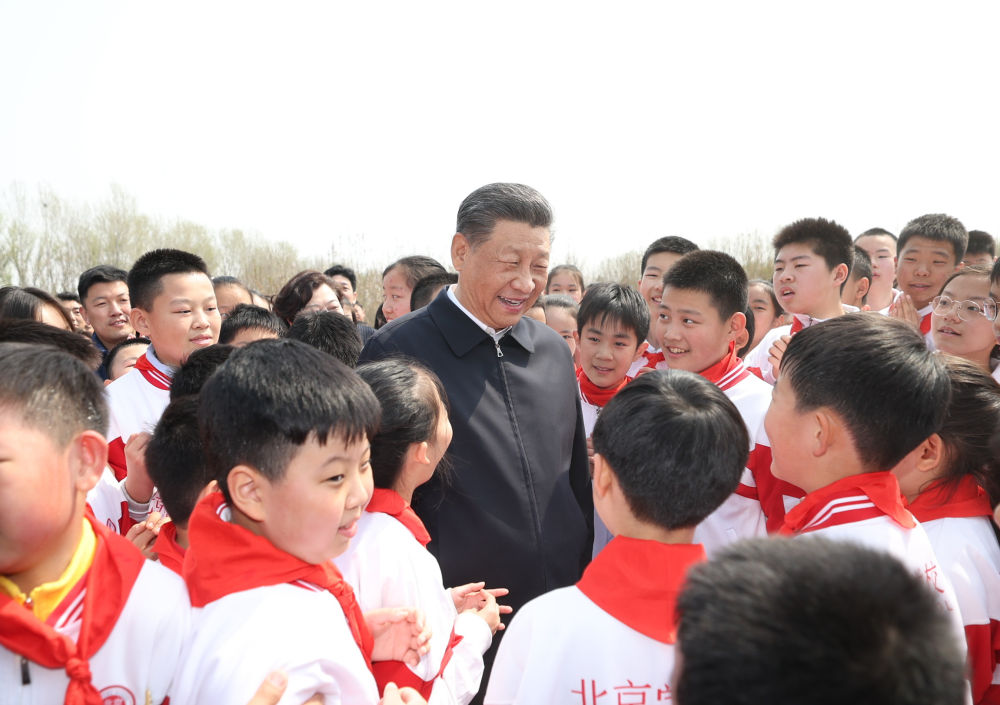 2024年4月3日，习近平等党和国家领导人来到北京市通州区潞城镇参加首都义务植树活动。这是习近平同少先队员在一起。