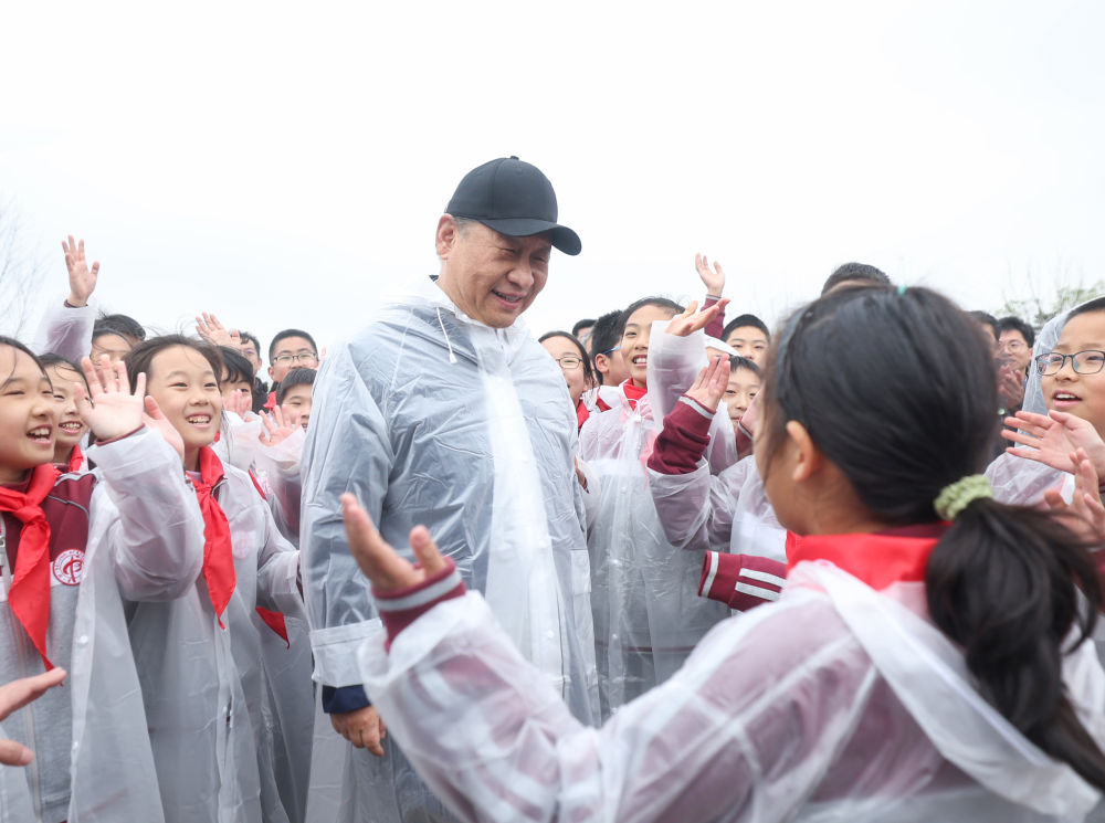 2023年4月4日，习近平等党和国家领导人冒雨来到北京市朝阳区东坝中心公园参加首都义务植树活动。这是植树后，习近平同在场的中小学生亲切交谈。