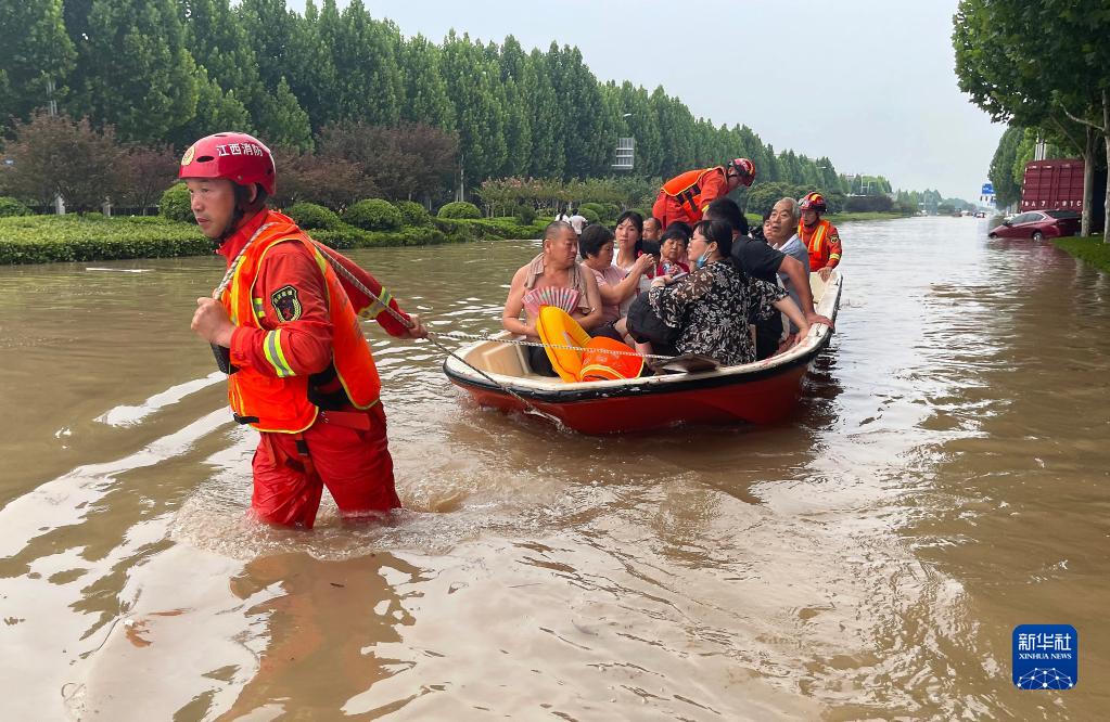 　　在河南省郑州市中牟县，李胜利（左一）在疏散被困群众（2021年7月19日摄）。新华社发（田聪 摄）