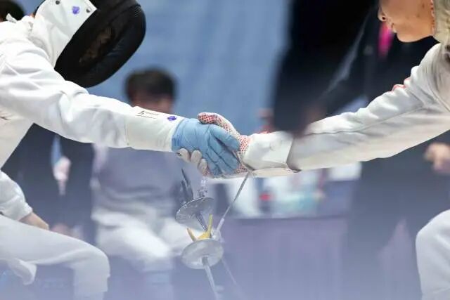 12月12日，在香港赛区男子花剑团体铜牌赛后，广东一团吴安迪（左）与对手握手。