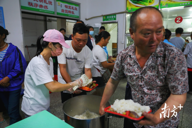 安置点内，工作人员在给群众打饭。