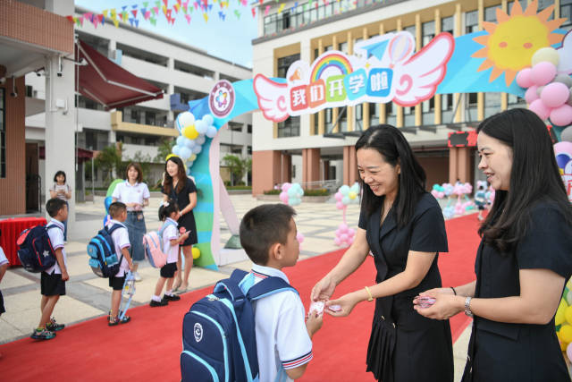 富强小学是今年秋季学期清远新启用的学校之一。走进校园的一年级新生从老师手中领取“新生入学礼”。南方+记者 曾亮超 摄